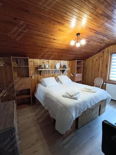 une chambre avec un grand lit dans une pièce aux murs en bois dans l'établissement Appartement meublé classé 3 étoiles de 72 m2, 2 chambres, à Morzine
