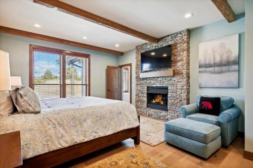 a bedroom with a bed and a fireplace at Dancing Rock "Grandview Lodge" (Caldera Springs) in Sunriver