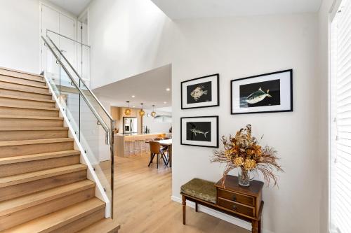 a staircase in a house with a vase of flowers at Seabreeze Escape - Snells Beach Holiday Home in Snells Beach