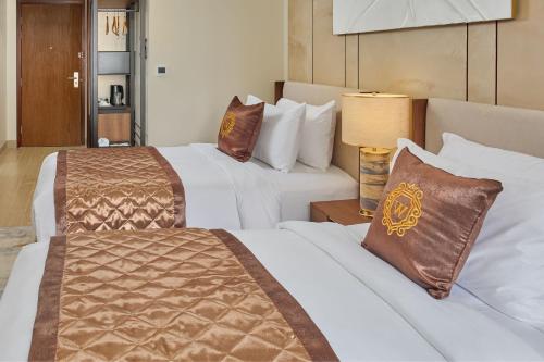 a hotel room with two beds and a lamp at Grand Westside Manila Bay in Manila