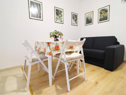 a dining room table and chairs with a couch at Apartments Nodilo - Standard One Bedroom Apartment with Balcony and Sea View Apt 2 in Goveđari