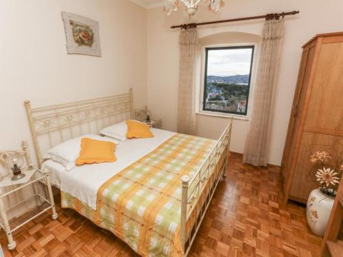 a bedroom with a bed with orange pillows and a window at Apartment with sea view in Orasac in Orasac
