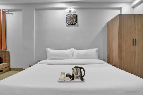 a bedroom with a white bed with a juicer on it at Super Townhouse Divya Palace in Indore