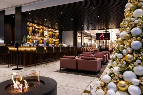 a christmas tree in a lobby with a bar at Hilton Garden Inn Vilnius City Centre in Vilnius