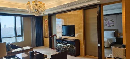 a living room with a television and a bedroom at InterContinental Shijiazhuang by IHG in Shijiazhuang