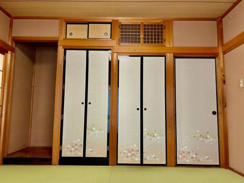 a room with three sliding glass doors with flowers at 広々な140平米 in Nagoya