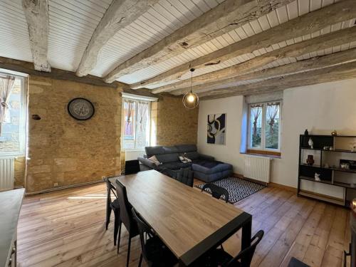 un salon avec une table en bois et un canapé dans l'établissement L'échappée Sarladaise - Gîte avec jardin, à Sarlat-la-Canéda