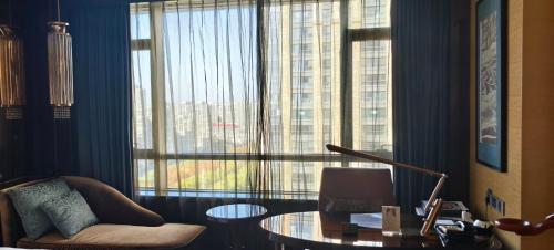 a living room with a table and a large window at InterContinental Shijiazhuang by IHG in Shijiazhuang