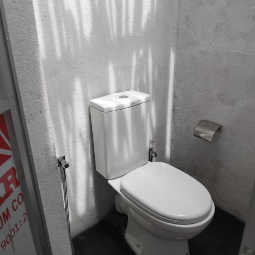 a bathroom with a white toilet in a stall at Hiricurry Hostel & Restaurant in Dickwella