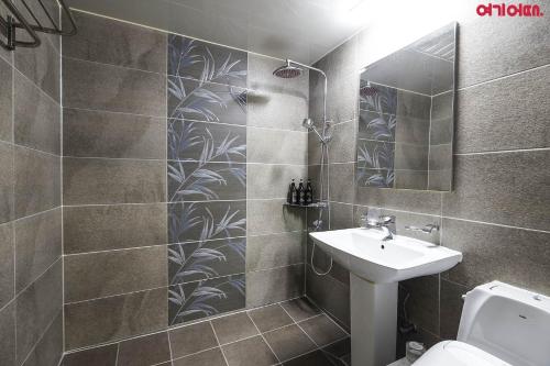 a bathroom with a sink and a toilet and a mirror at Bed Station in Incheon
