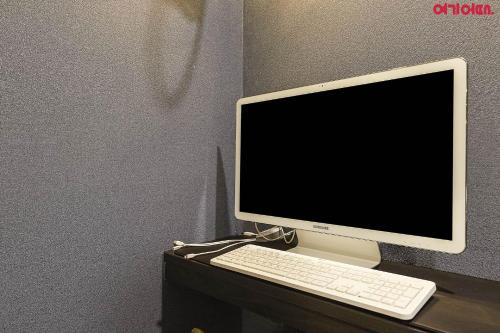 a computer monitor and a keyboard on a desk at Bed Station in Incheon
