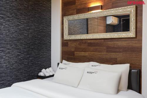 a bedroom with two white beds and a mirror at Bed Station in Incheon