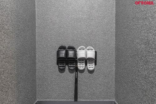 a row of black and white shoes in a wall at Bed Station in Incheon