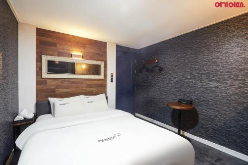 a bedroom with a white bed and a wall at Bed Station in Incheon