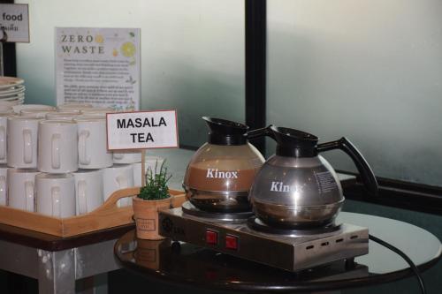 a table with two coffee makers on a table with cups at Heeton Concept Hotel Pattaya by Compass Hospitality in Pattaya Central