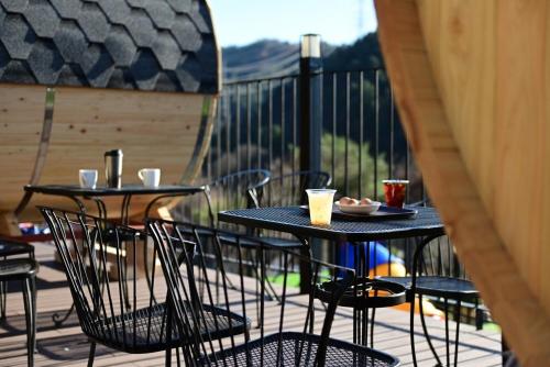 two tables and chairs on a deck with drinks at Hahaha Pension in Gapyeong