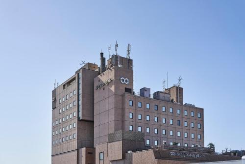 a building with a clock on the top of it at Saitama Grand Hotel Honjo in Honjo