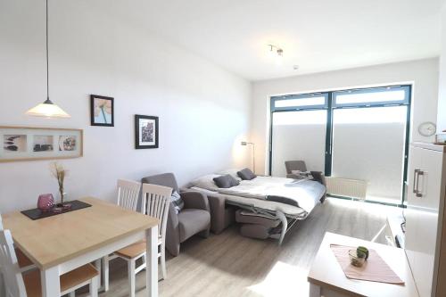 a living room with a couch and a bed and a table at 02 Ferienwohnung Strandnest 1 Strandburg App.0.2 rechts in Burgtiefe auf Fehmarn 