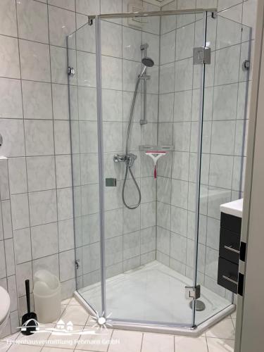 a shower with a glass door in a bathroom at 06 Ferienwohnung Heimathaven App.68-112 in Burgtiefe auf Fehmarn 