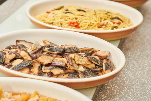 three bowls of food on a table with pasta at Saitama Grand Hotel Honjo in Honjo