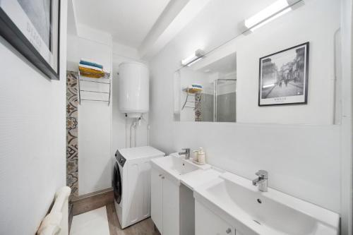 une salle de bain blanche avec un lavabo et un miroir dans l'établissement Le Refuge Dijonnais, à Dijon