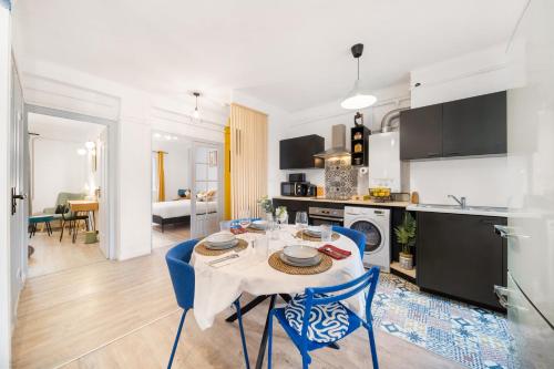 une cuisine et une salle à manger avec une table et des chaises bleues dans l'établissement Le Refuge Dijonnais, à Dijon