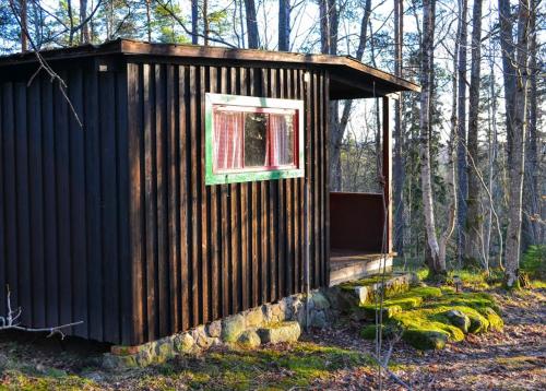 a small cabin in the woods with a window at Marston Hill in Mullsjö