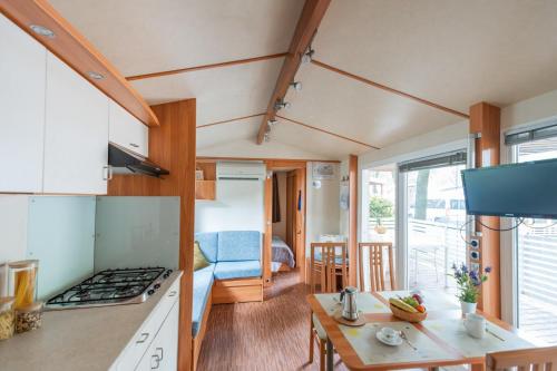 a kitchen and living room with a stove top oven at Club del Sole Jesolo Family Resort in Lido di Jesolo