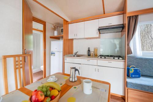 a kitchen with a table with a bowl of fruit on it at Club del Sole Jesolo Family Resort in Lido di Jesolo