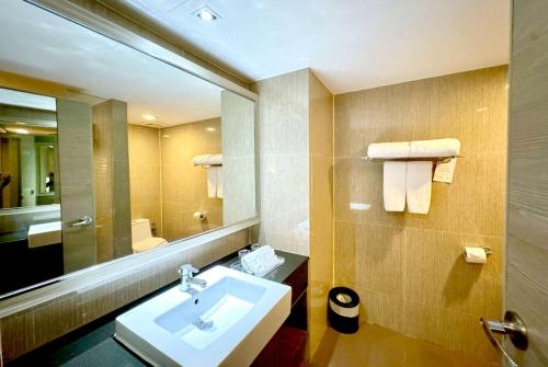 a bathroom with a sink and a mirror at Ramada Sukhumvit Soi Eleven in Bangkok