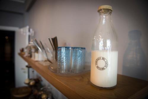 a bottle of milk sitting on a wooden shelf at Ciauru Design B&B in Messina