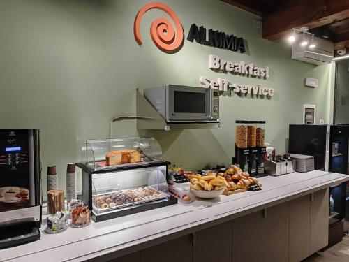 a bakery with a counter with pastries on it at Alkimia Smart Rooms in Ferrara