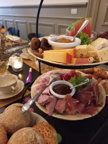 a table with two plates of cheese and meats and bread at B&B La Corderie in Hamme