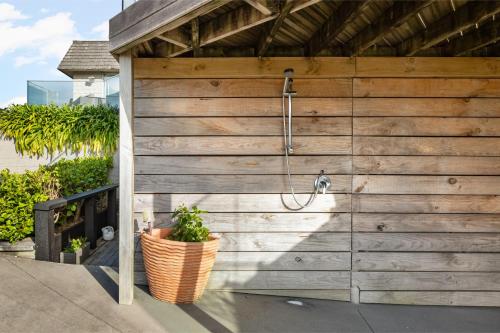 a wooden wall with a shower in a bathroom at Two Palms - Waihi Beach Holiday Apartment in Mangonui