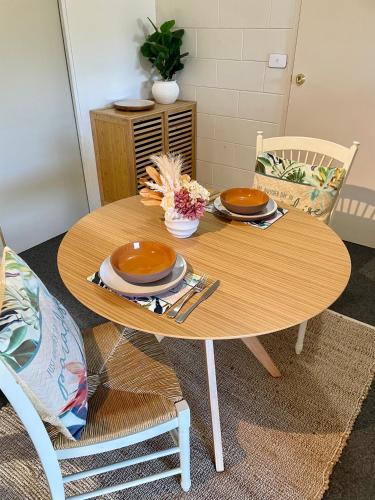 a wooden table with plates and utensils on it at White Rabbit Mountain Guest House in Mount Beauty