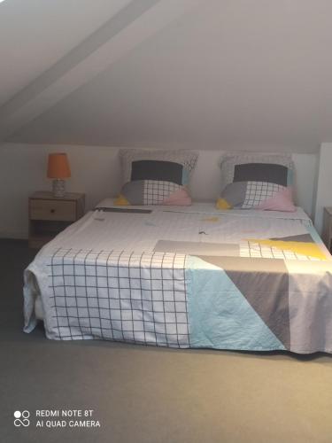 a bedroom with a large white bed with pillows at Petit appartement dans une maison individuelle in Le Tampon