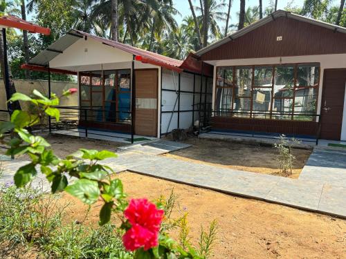 a house with a red flower in front of it at My Dream Resort in Canacona