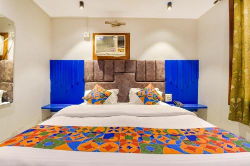 a bedroom with a large bed with a colorful bedspread at FabHotel Prem Bihari in Haridwār