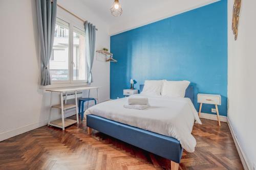 - une chambre bleue avec un lit et un bureau dans l'établissement Champs de Mars - T5 chic, 4 chambres, tout équipé, à Toulon