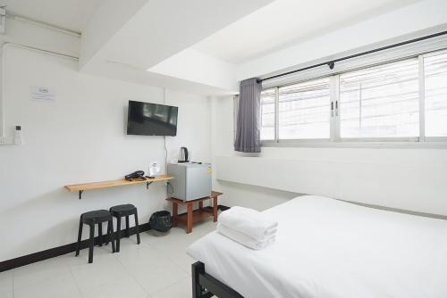 a room with two beds and a desk and a window at GO INN Bangkok Rama3 โกอินน์ พระราม3 in Bangkok