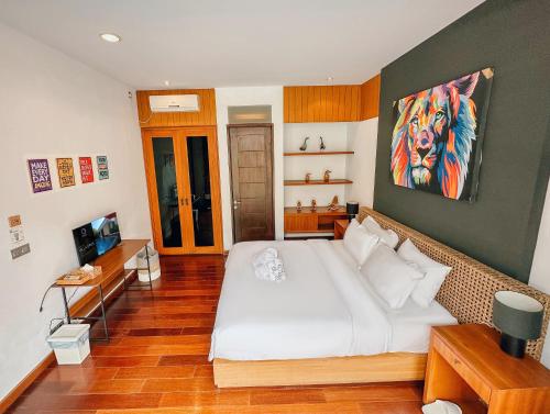 a bedroom with a large bed with a painting on the wall at Villa Nusa Dua by Opus Hospitality in Nusa Dua