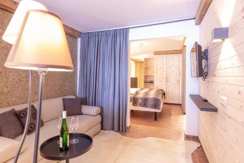a living room with a couch and a table with a lamp at Quality Hosts Arlberg - Hotel Bergheim in Sankt Anton am Arlberg