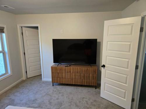 a living room with a flat screen tv and a door at Spacious Modern Retreat Near Downtown in Huntsville