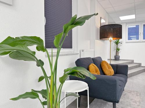 a blue couch in a living room with a plant at Gruppenfreundl Komfort Apt für 18 im Zentrum Stuttgarts in Stuttgart