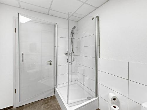 a shower with a glass door in a bathroom at Gruppenfreundl Komfort Apt für 18 im Zentrum Stuttgarts in Stuttgart