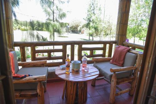 a porch with a table and chairs and a view of a field at Sangare Gardens- Book Now Enjoy Free Farm Tour in Mweiga