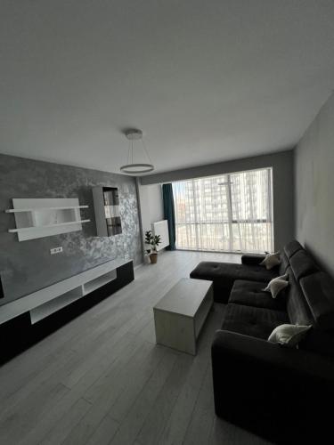a living room with a black couch and a table at Apartament in Craiova
