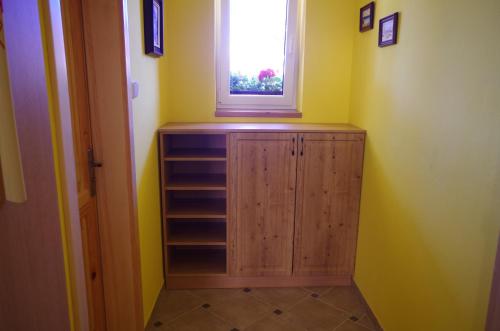 a room with a wooden cabinet and a window at Ubytování a apartmány Sluníčko in Lomnice nad Lužnicí