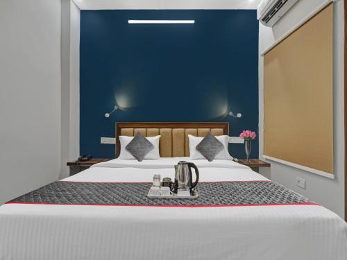 a bedroom with a large bed with a blue wall at Super Super Townhouse Swaroop Inn in Chinhat