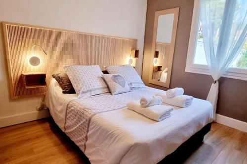 une chambre avec un grand lit avec des serviettes dessus dans l'établissement La Maison de la Plage, à Argelès-sur-Mer